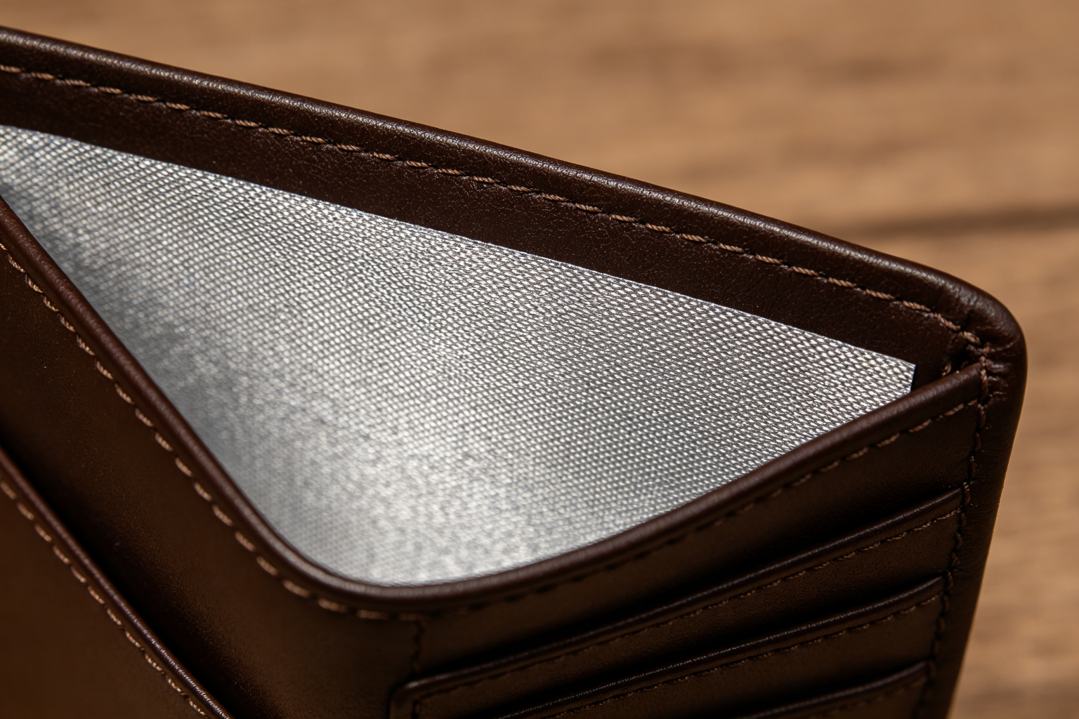 Close-up of the RFID blocking metallic shielding layer inside a PU leather wallet showing the lining texture and stitching