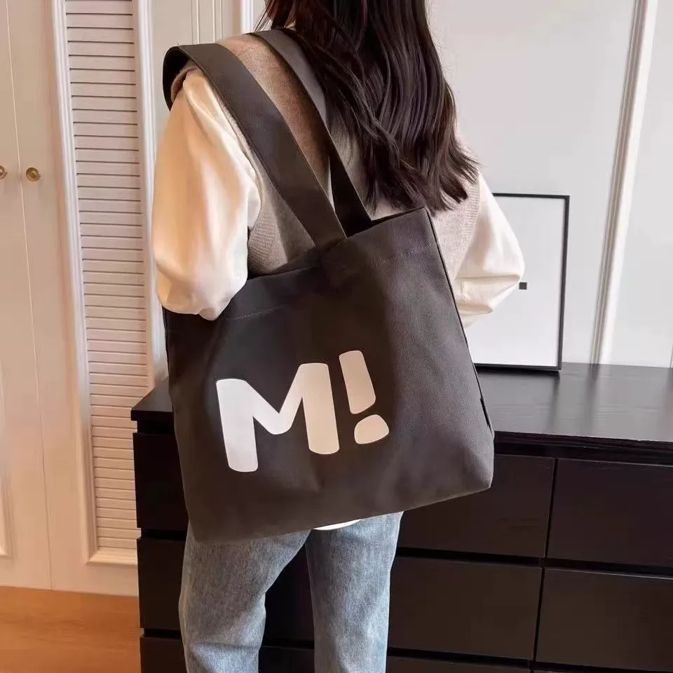 Canvas shopping tote back view showing letter print design