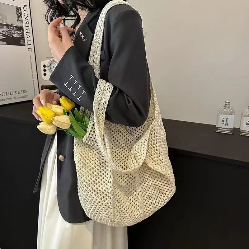 Model carrying crocheted tote over shoulder, street style