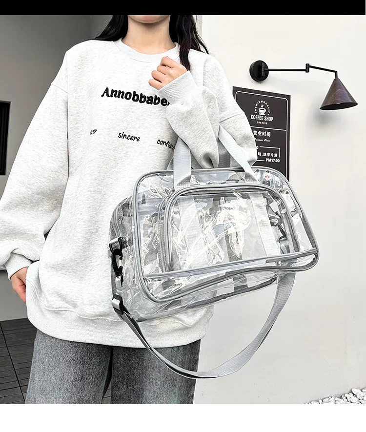 Model holding clear PVC duffel bag by handle, casual travel look