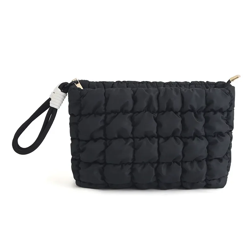 Cloud-puffer cosmetic bag showing padded quilt grid and metal zipper pull