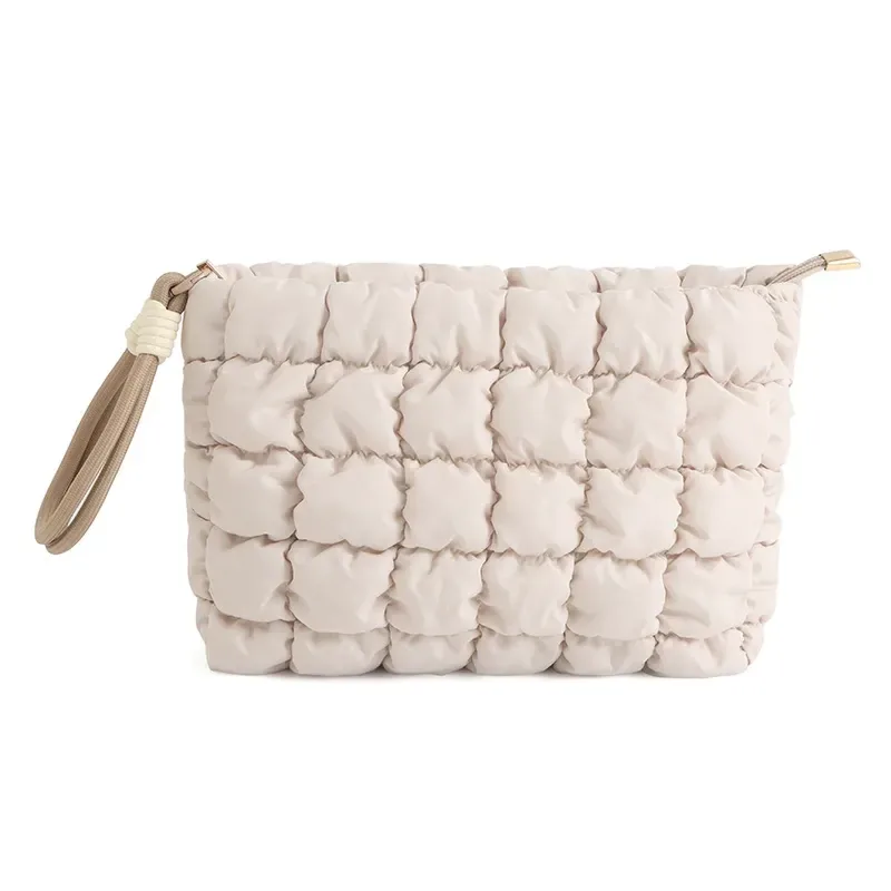Beige quilted cloud-puffer cosmetic bag with braided side strap on white background