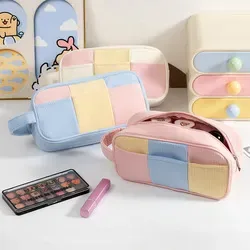 Colorblock canvas pouch styled with makeup and stationery items
