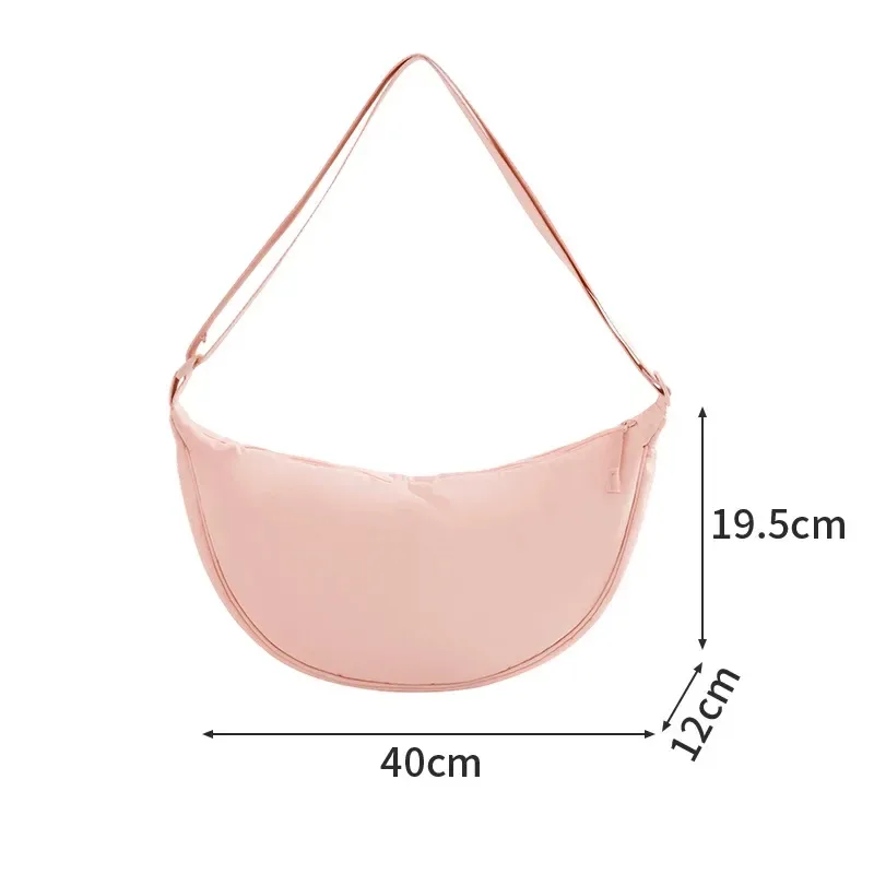 Pink crescent nylon crossbody bag with adjustable strap on white background