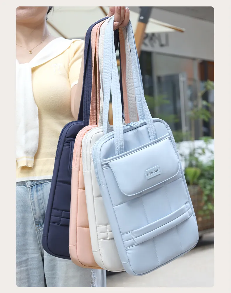 Multiple pastel colors of single shoulder laptop bags held by hand