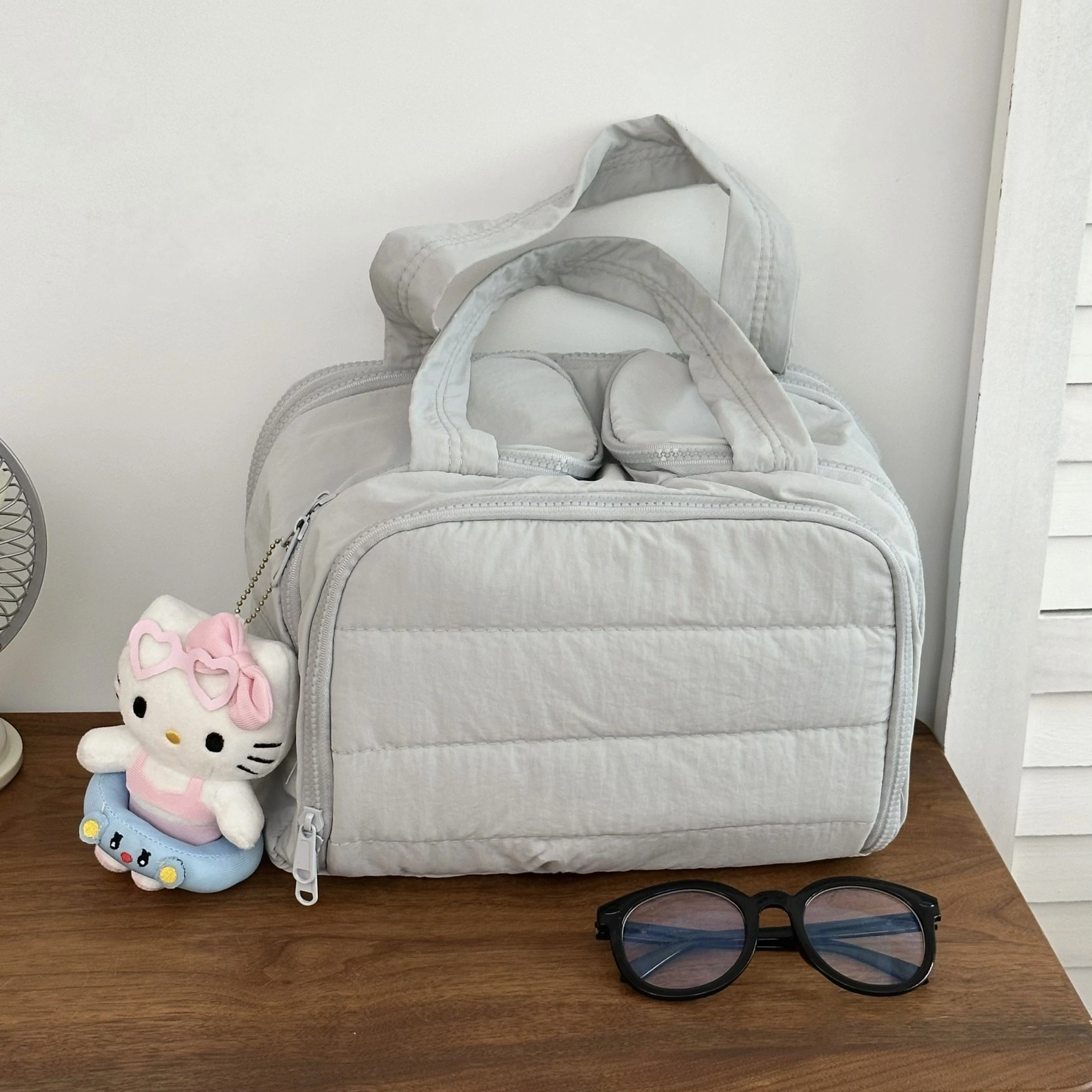 Puffy Oxford duffel bag in grey, isolated.