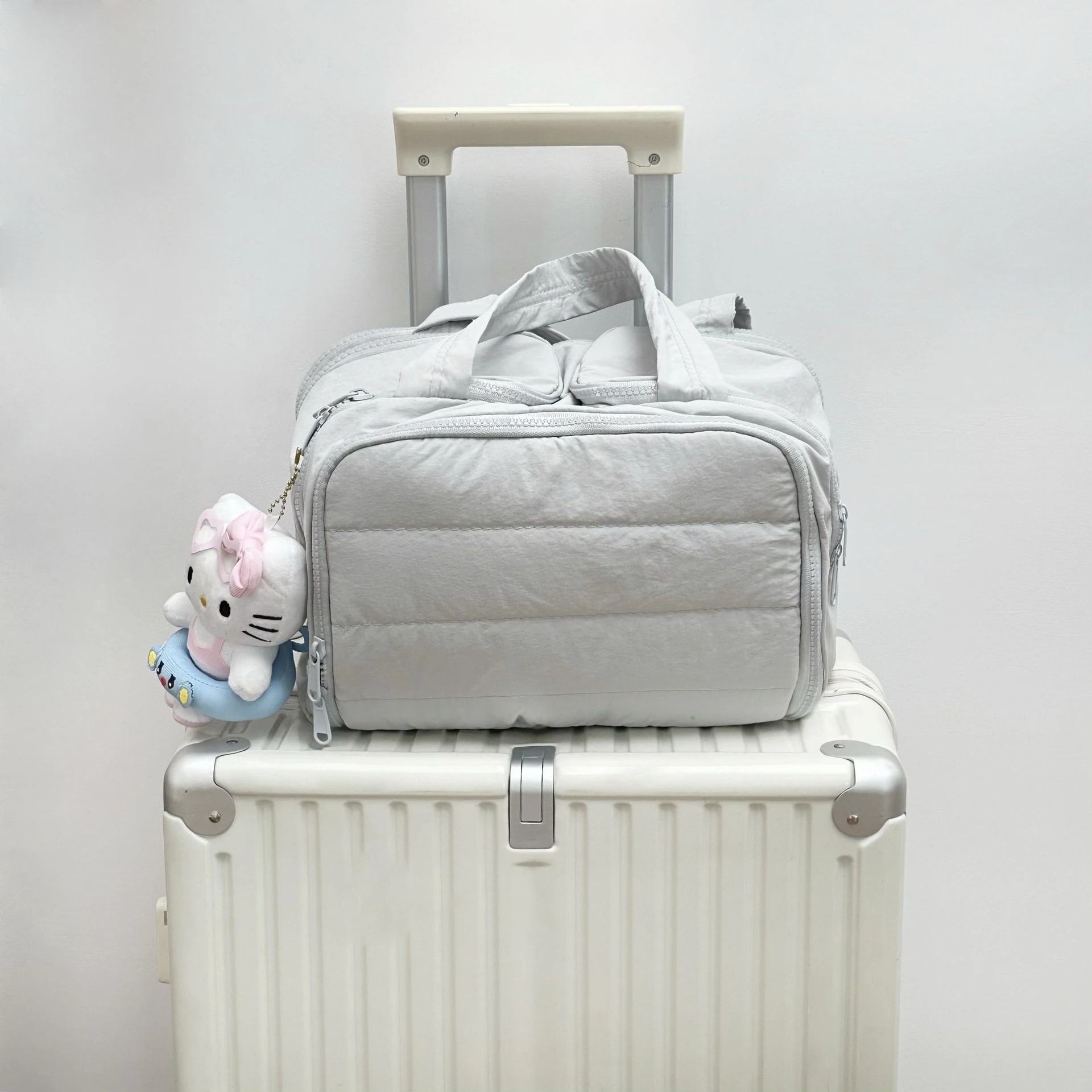 Puffy travel weekender bag showing accessories storage and decorative charm