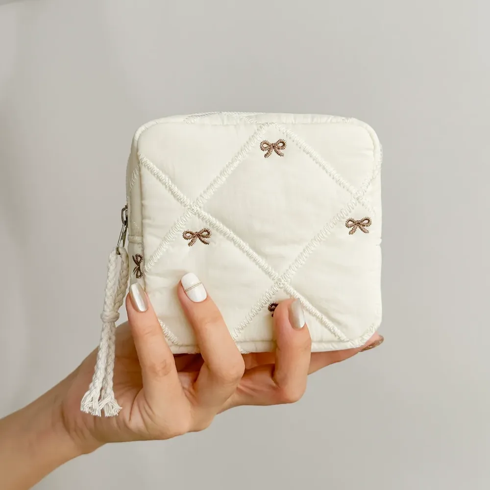 Quilted bow cosmetic bag in caramel and cream colorways