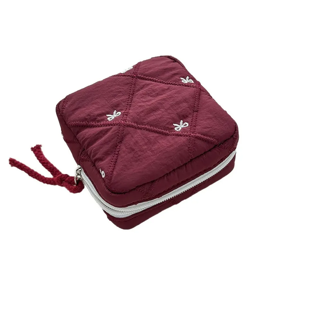 Quilted bow pouch showing embroidered bow motif and drawcord closure