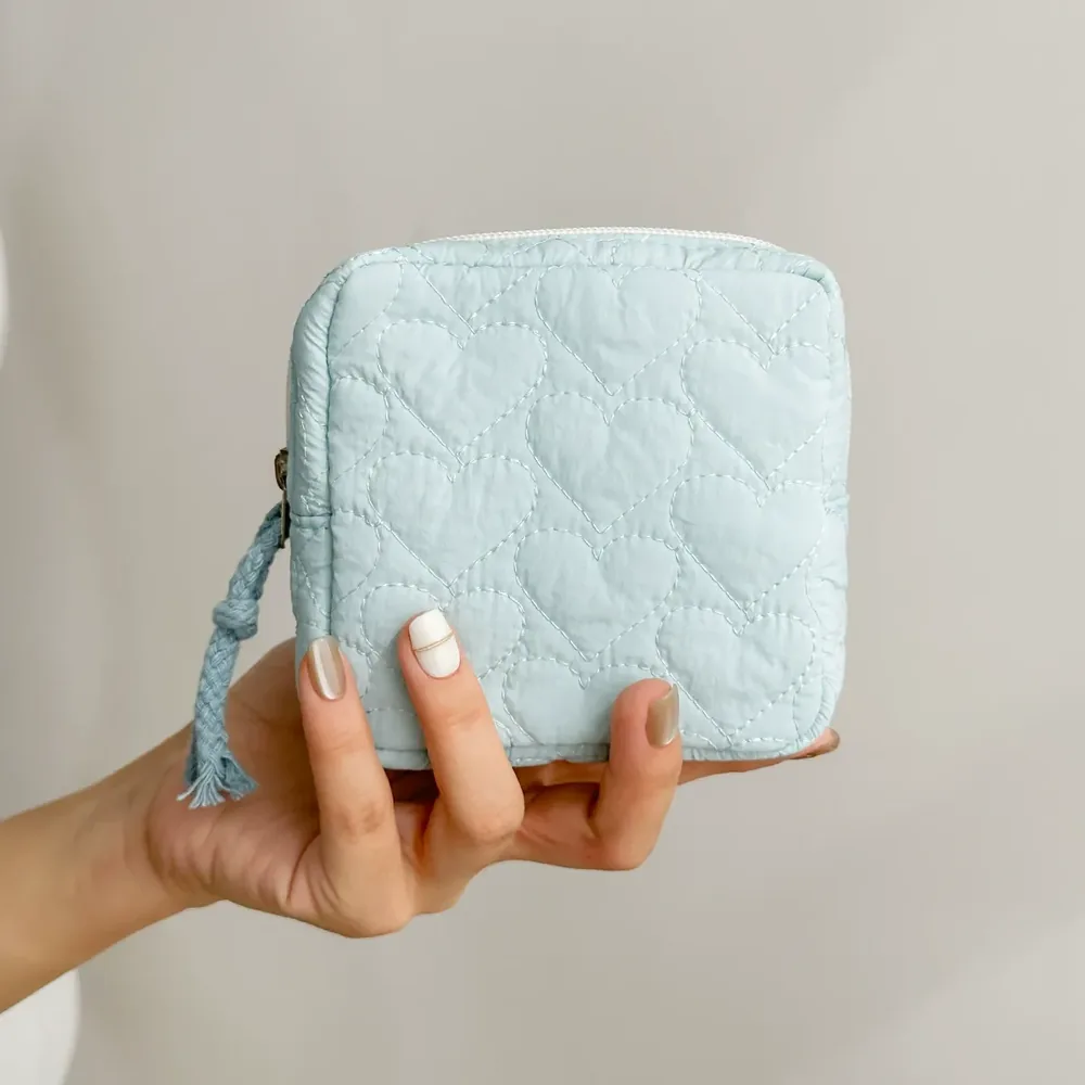 Quilted bow bag styled with a book and coins as a cozy flat lay