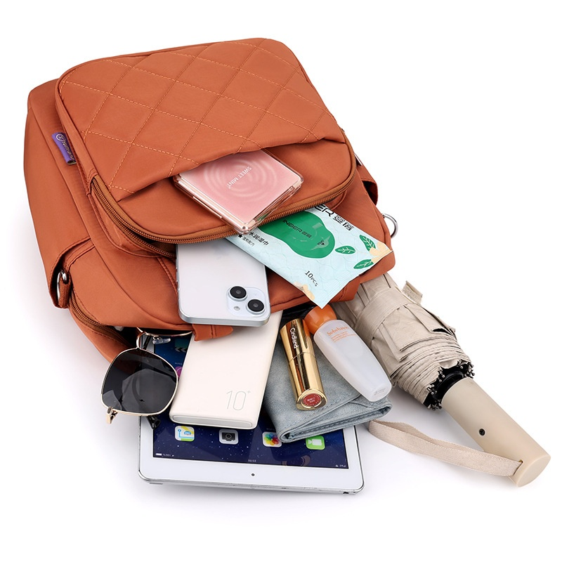 Interior capacity display of quilted nylon backpack holding tablet, umbrella, cosmetics and daily essentials