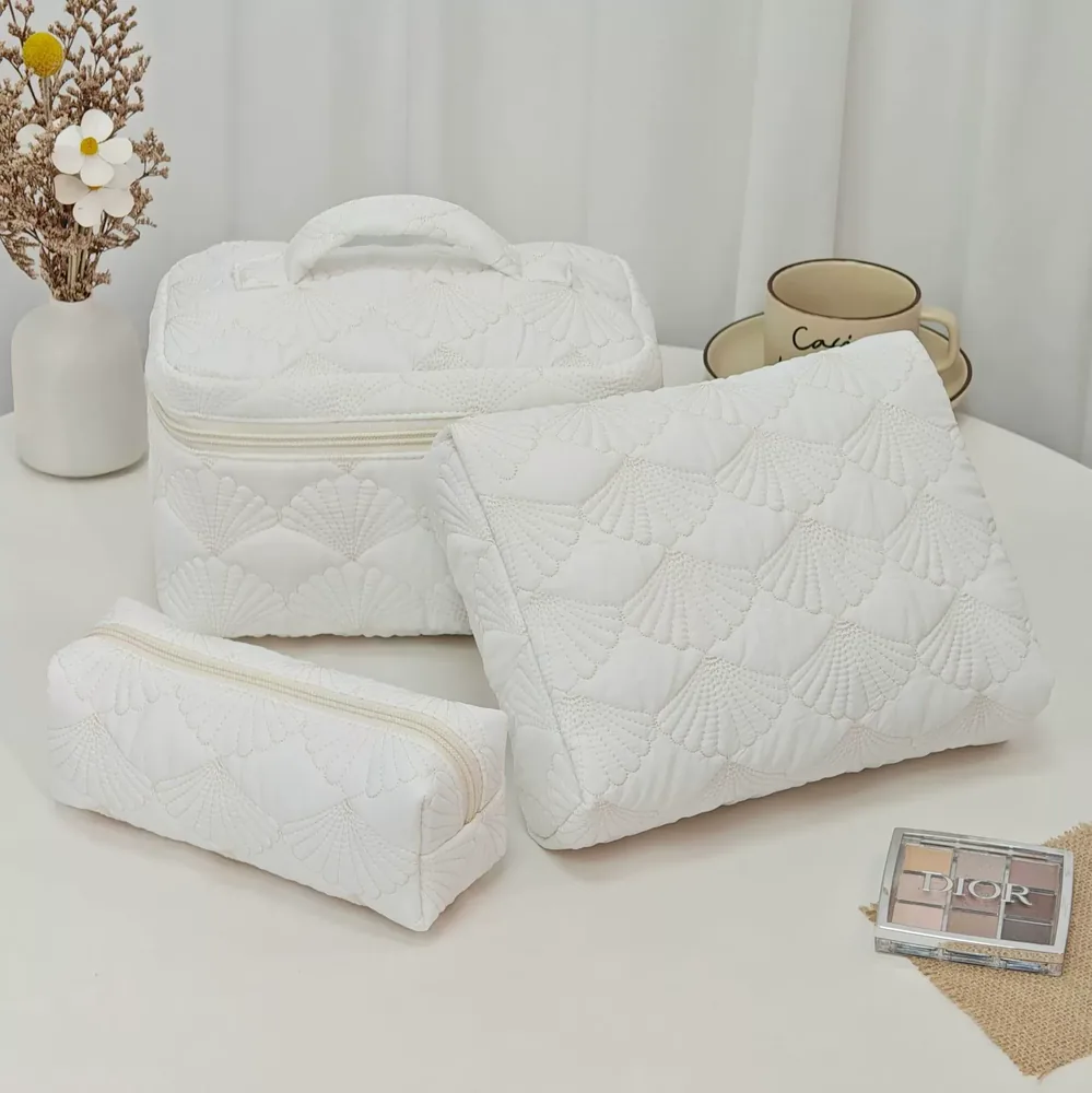 Quilted shell cosmetic bag showing scalloped stitch pattern and zipper