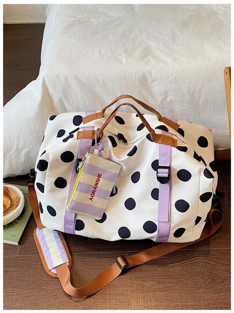 White polka dot duffel showing fabric texture and zipper detail
