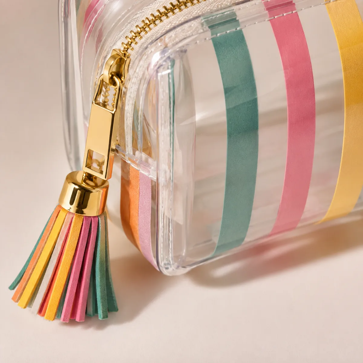 Close-up of reinforced stitching and gold zipper hardware on striped canvas cosmetic bag