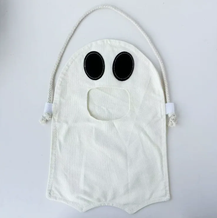 White ghost-shaped Halloween candy tote bag with black face print and drawstring top