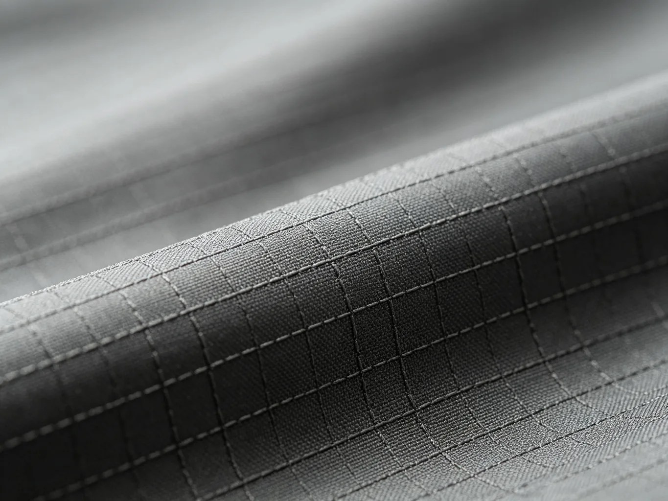 Ripstop nylon fabric texture close-up, charcoal gray