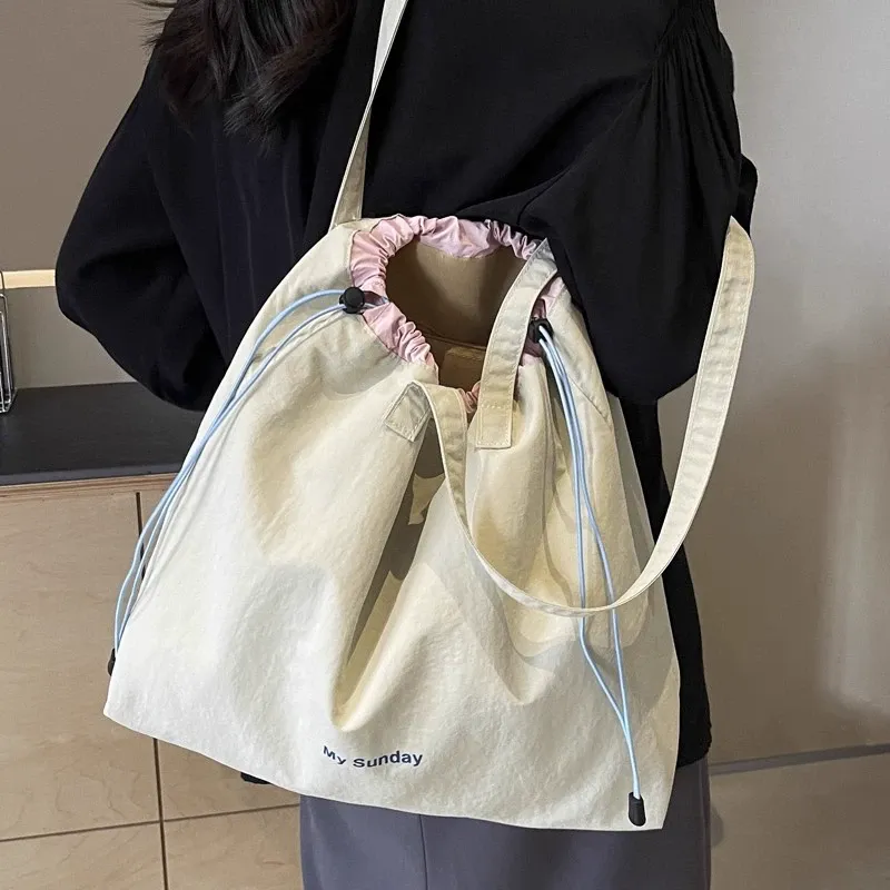 Model carrying nylon tote over shoulder, casual commute style