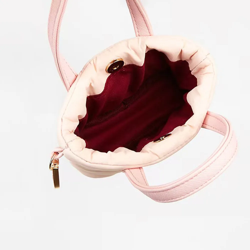 Interior detail of quilted mini nylon bag with wine red polyester lining and gold zipper