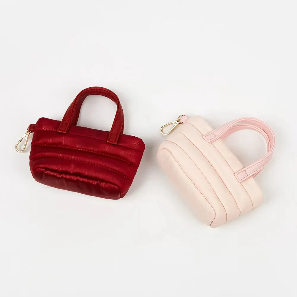 Mini quilted nylon pouch styled as a handbag accessory with gold clip